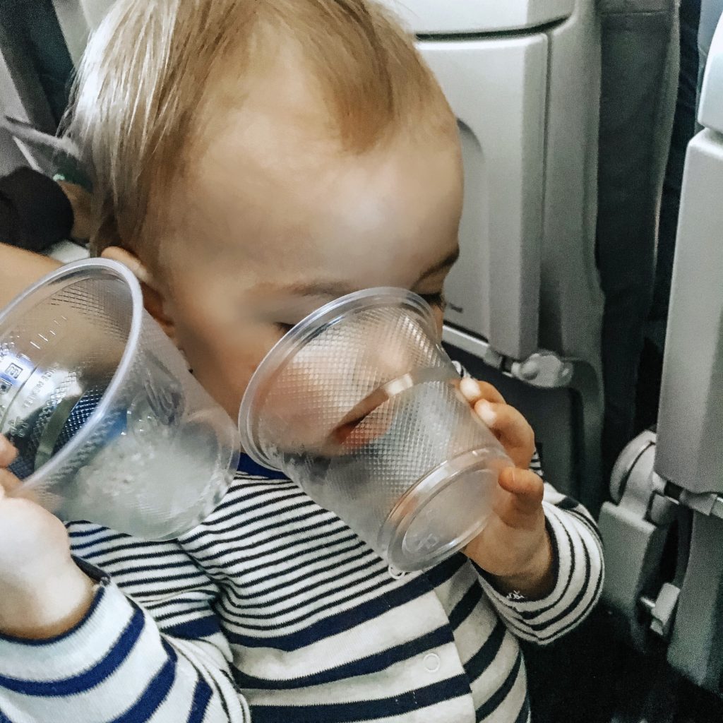 baby with cups on plane